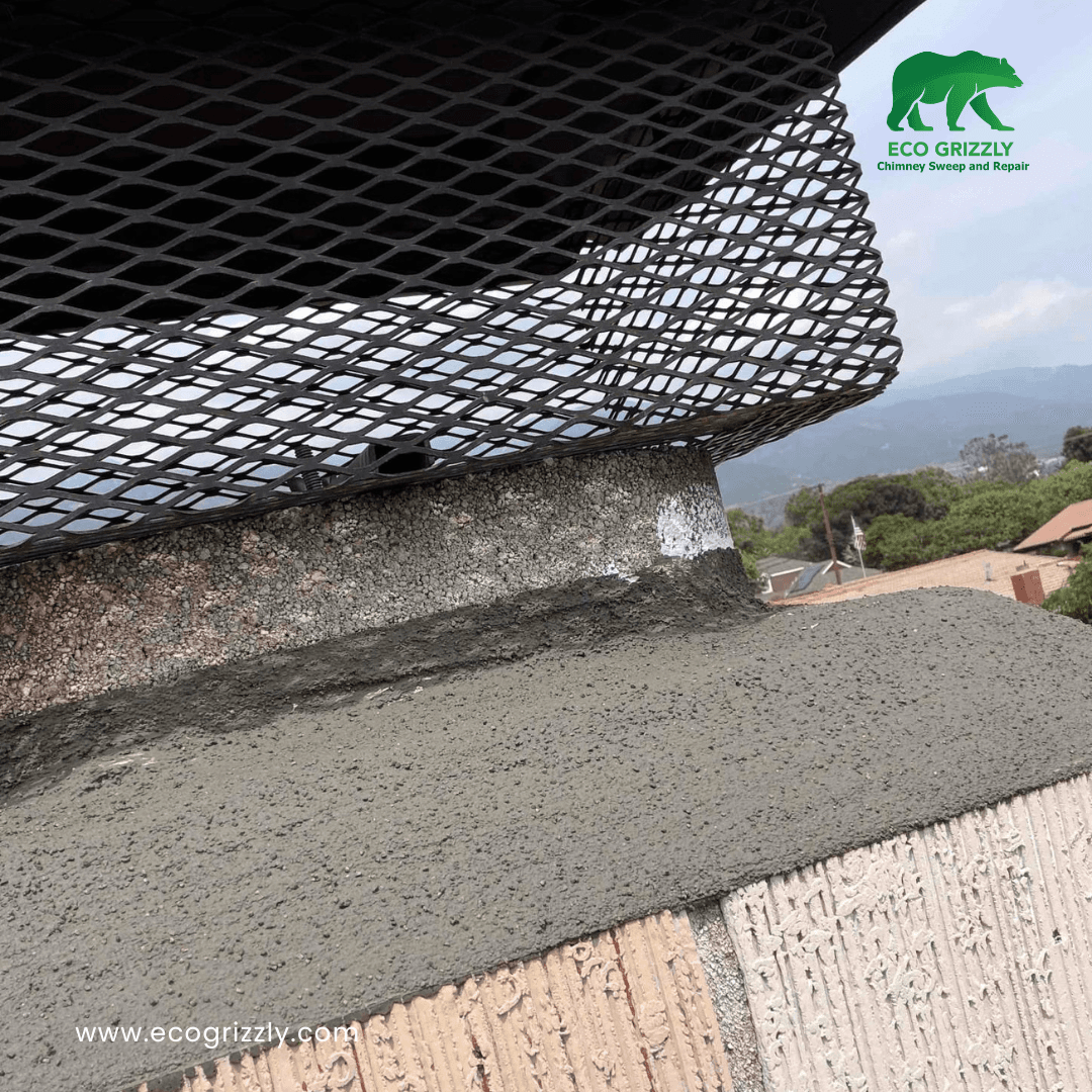 Close-up of chimney crown being repaired with new mortar and a metal mesh cap