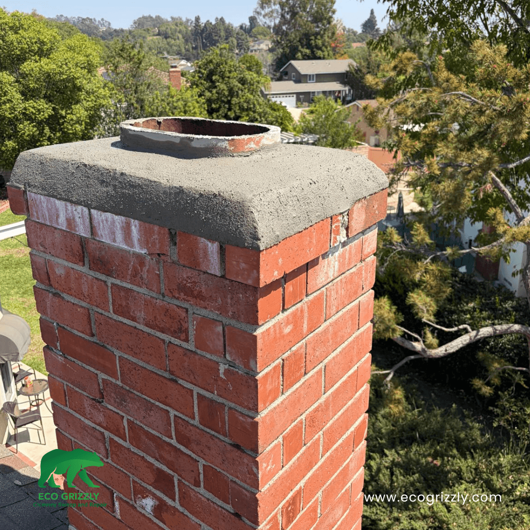 Brick chimney with newly repaired concrete crown and visible metal flue liner