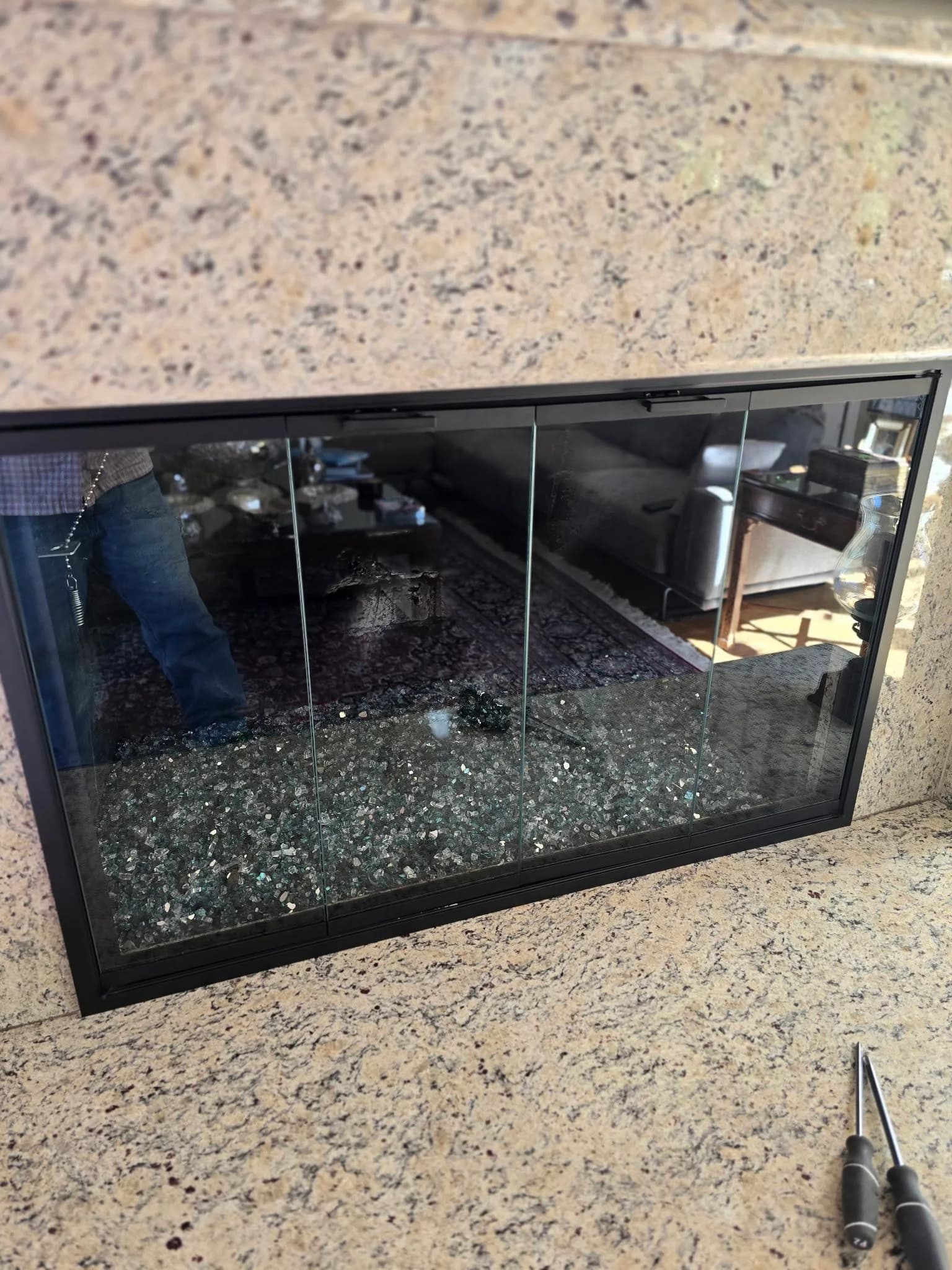 Bi-fold glass door frame being fitted to a brick fireplace opening during installation