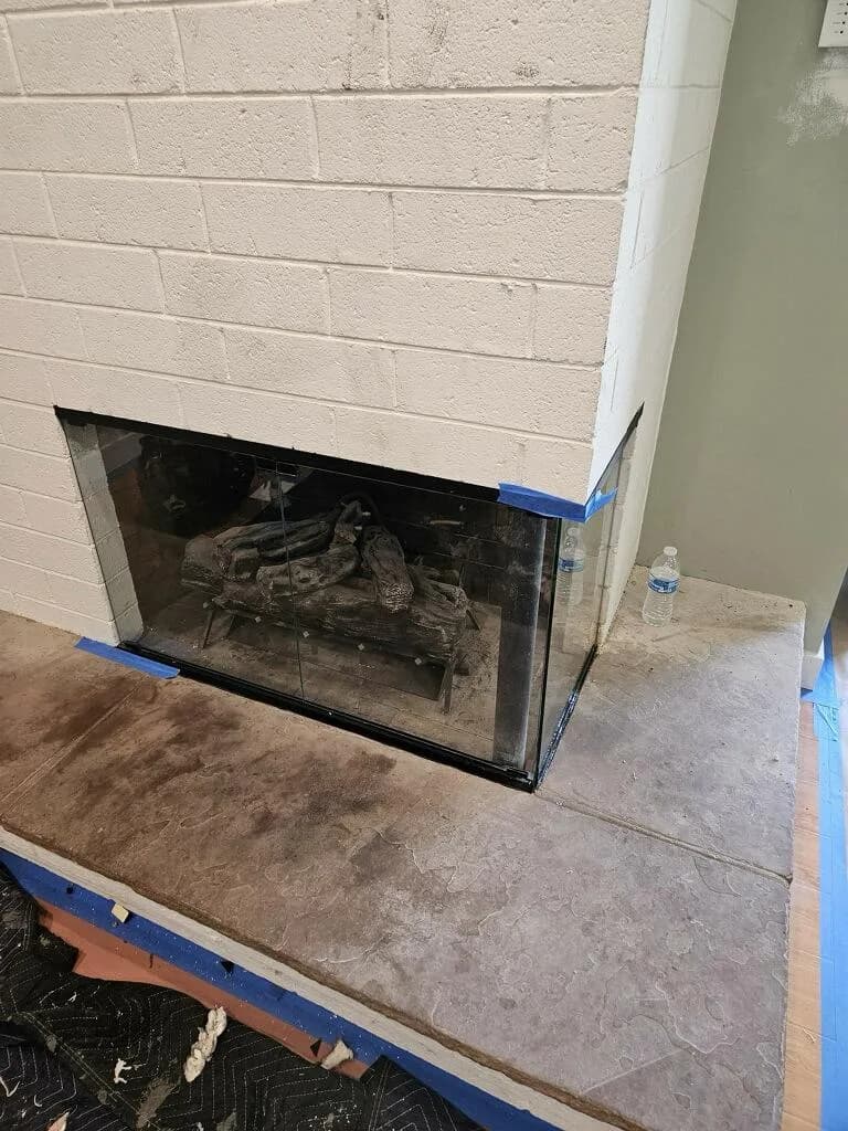 Finished fireplace glass door set installed on a wood-burning masonry fireplace