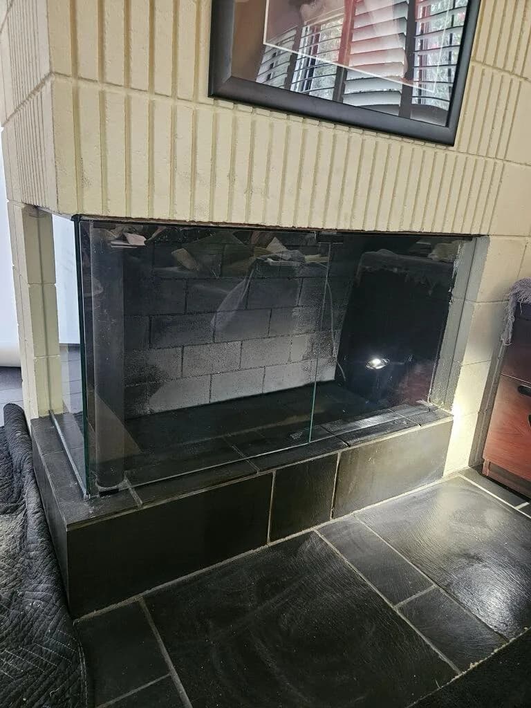 Fireplace glass door installation detail showing frame alignment and glass panel fit