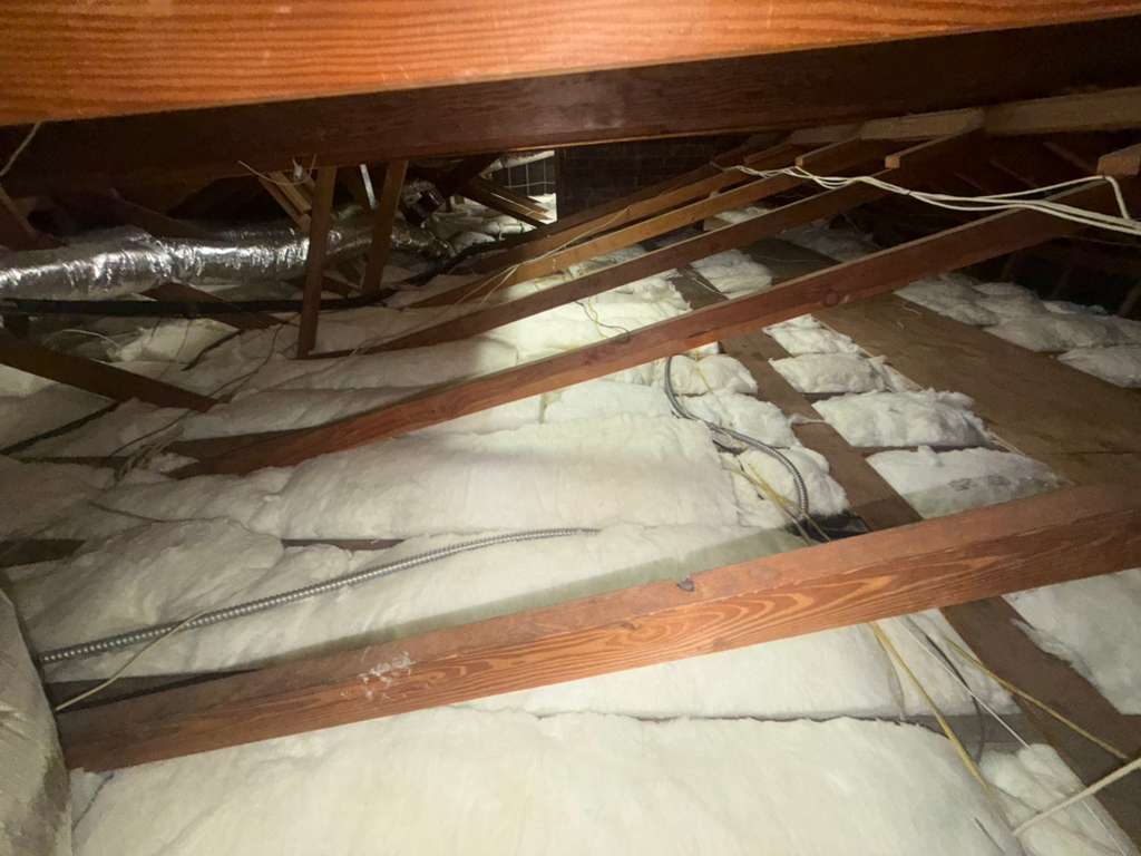 Newly installed attic insulation with even coverage across joists