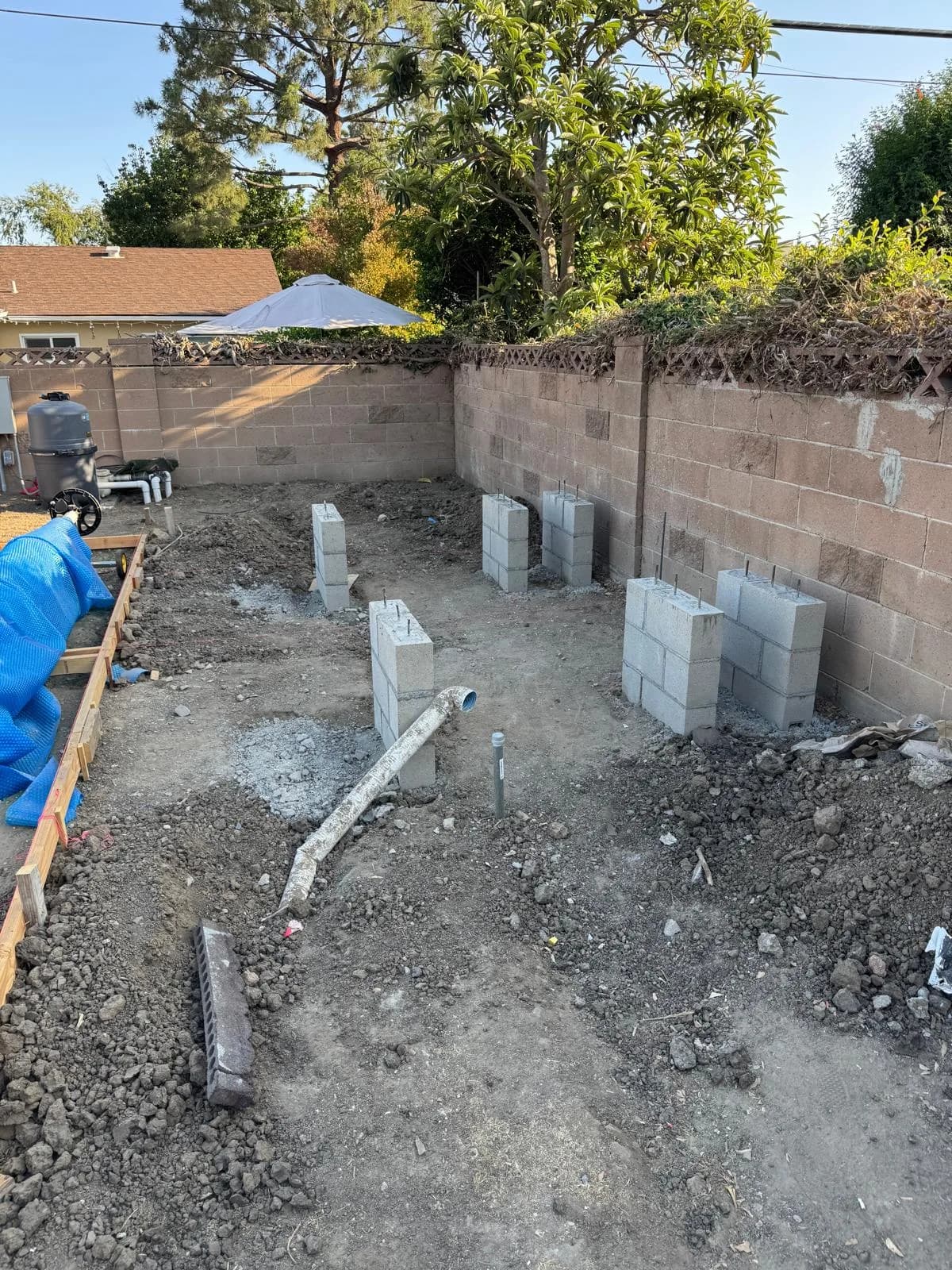 Cinder block foundation for a backyard fire pit and seating area set in dirt during construction