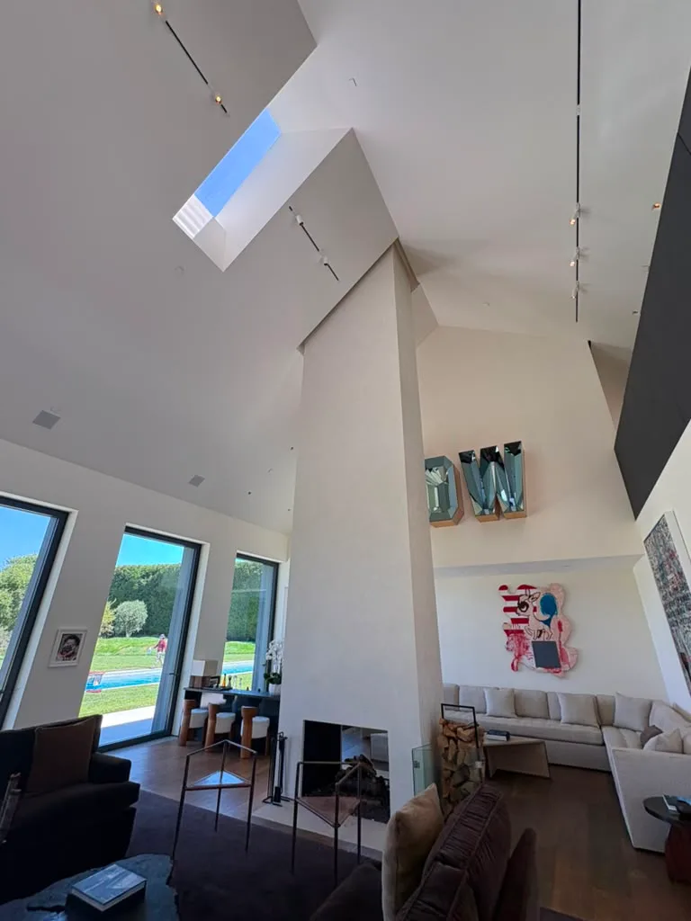 Finished fireplace column reaching the vaulted ceiling below a skylight in the living room