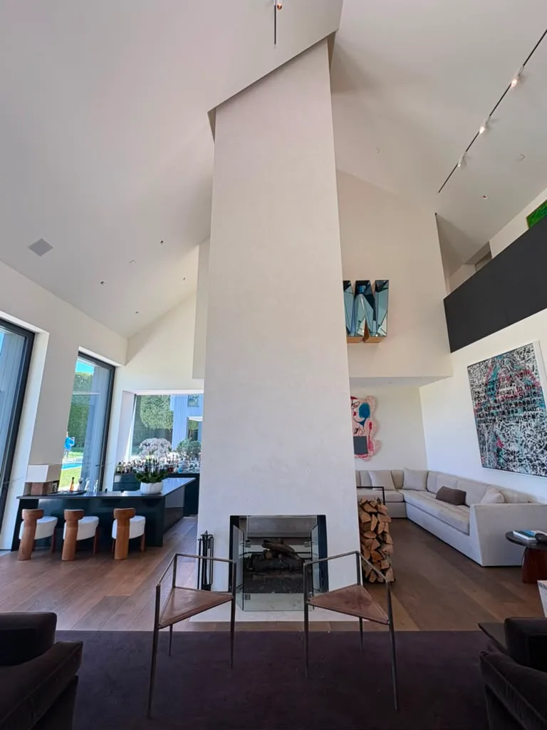 Living and dining space anchored by the finished plaster fireplace column and fire screen