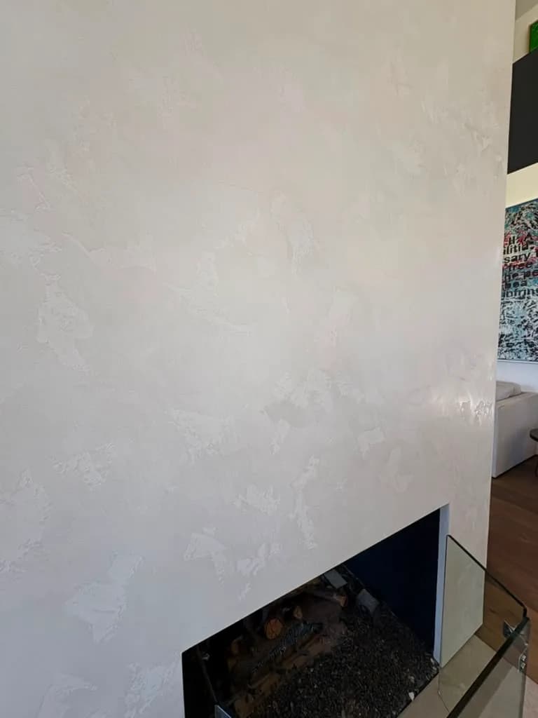 Close view of the plaster column edge meeting the dark firebox opening