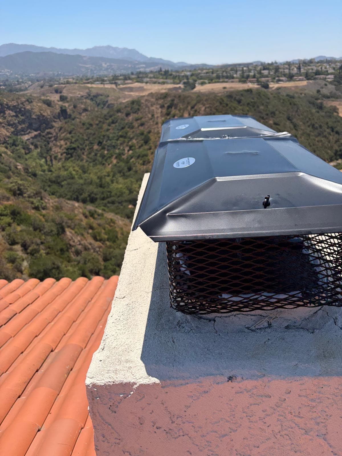 New stainless steel chimney cap installed on flue