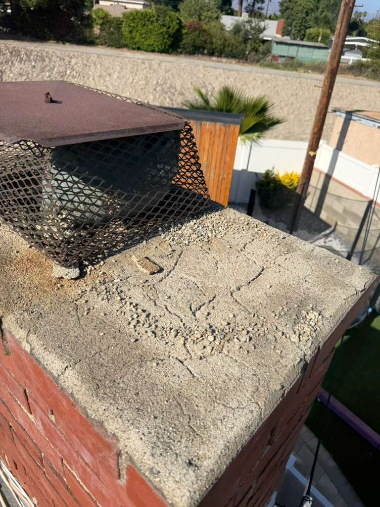 Porous and spalled chimney crown before waterproofing