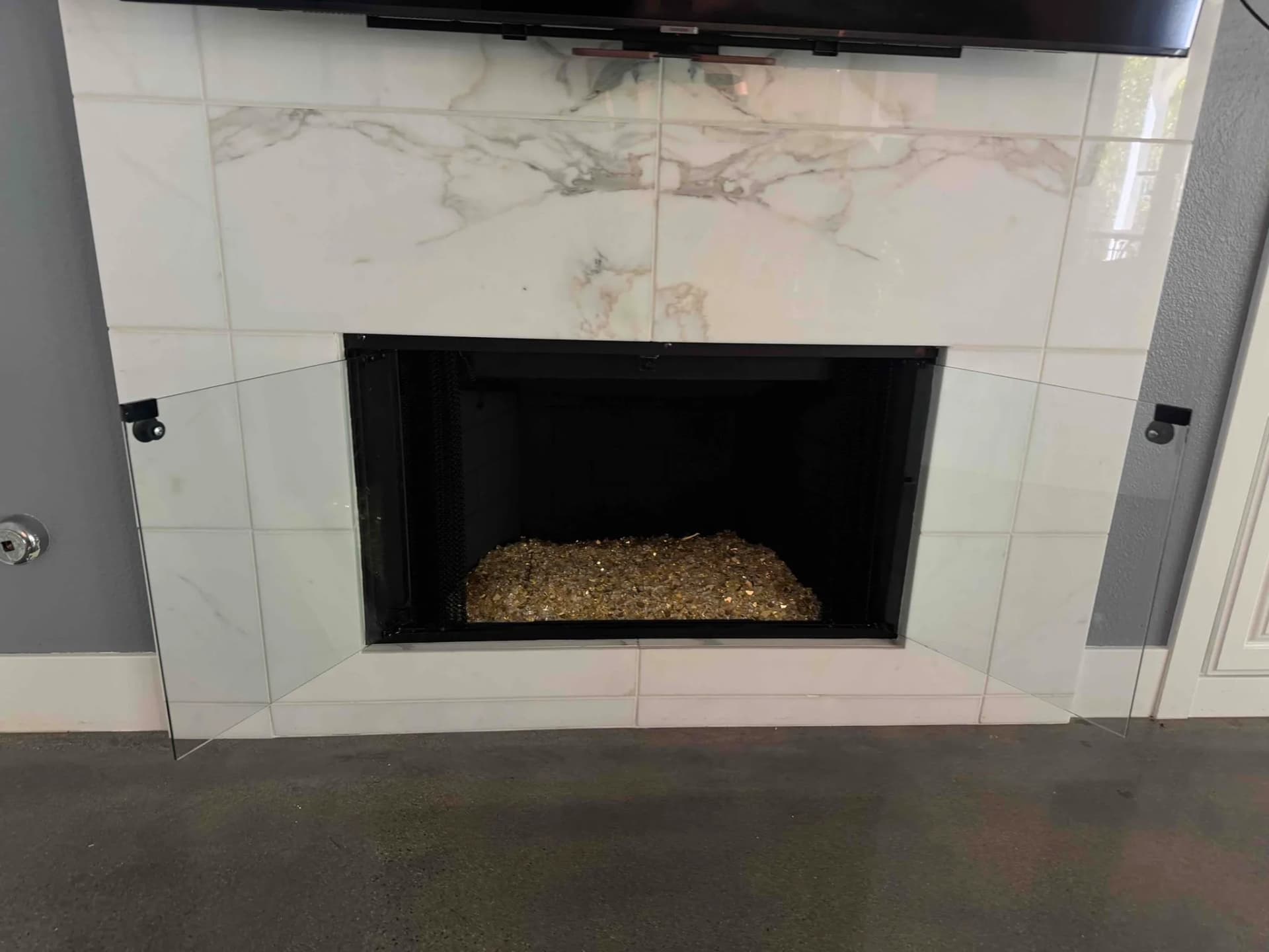 Masonry fireplace before glass door installation showing open firebox
