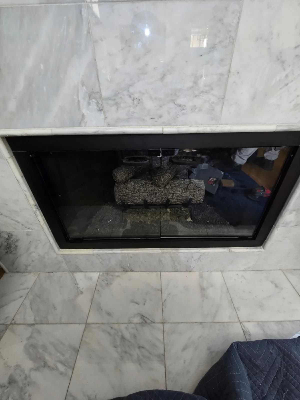 Finished fireplace glass door installation showing clean frame and glass panels