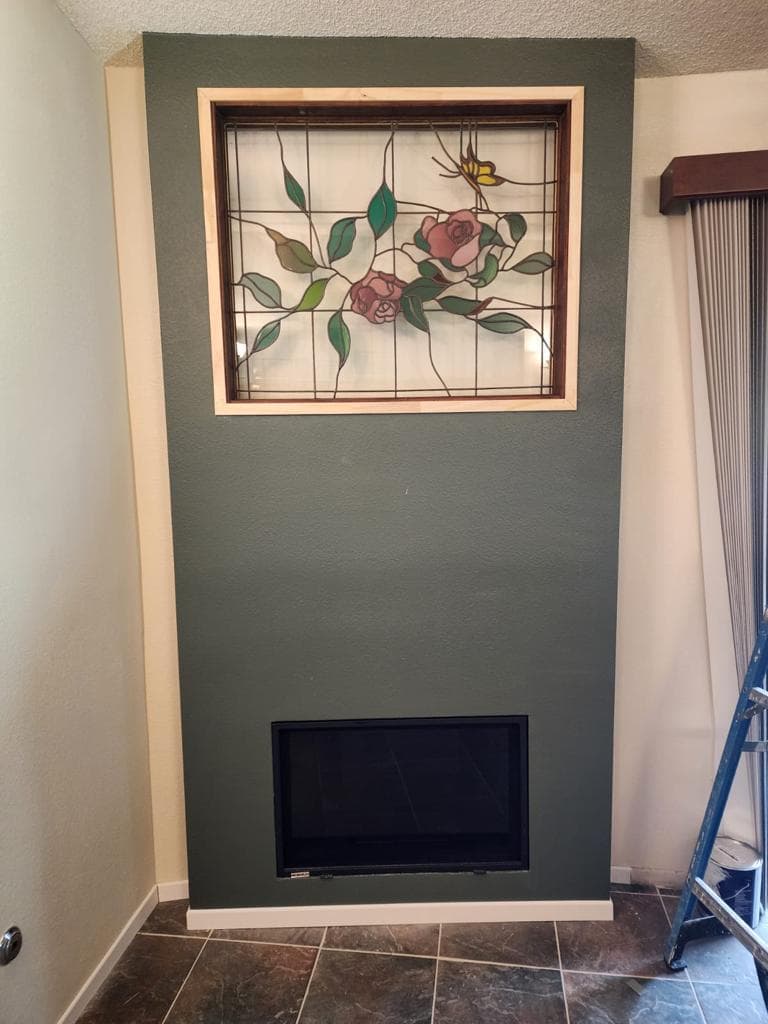 Completed fireplace insert installation and remodel with finished custom surround