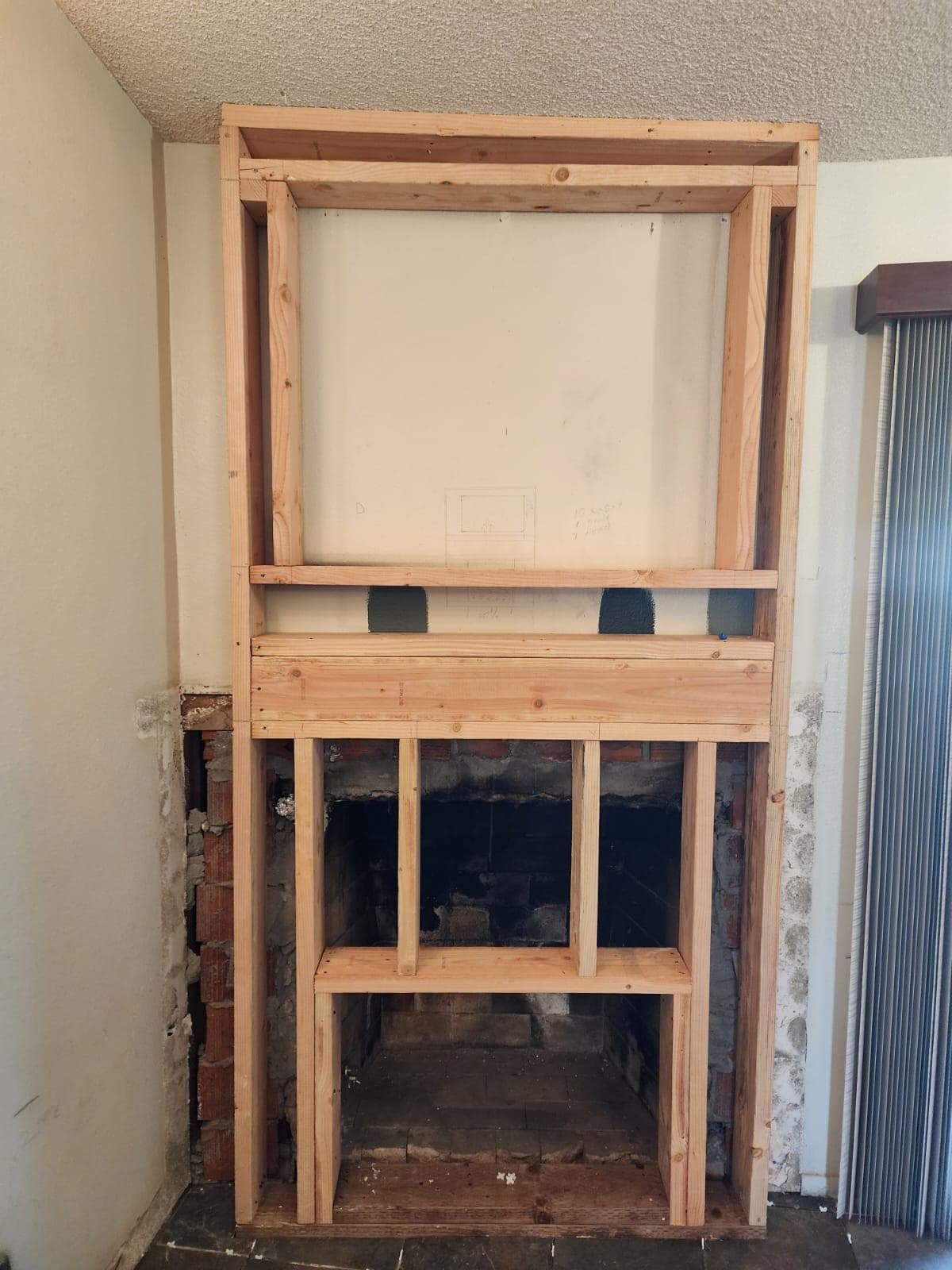 Fireplace insert installation in progress with new framing and surround being fitted