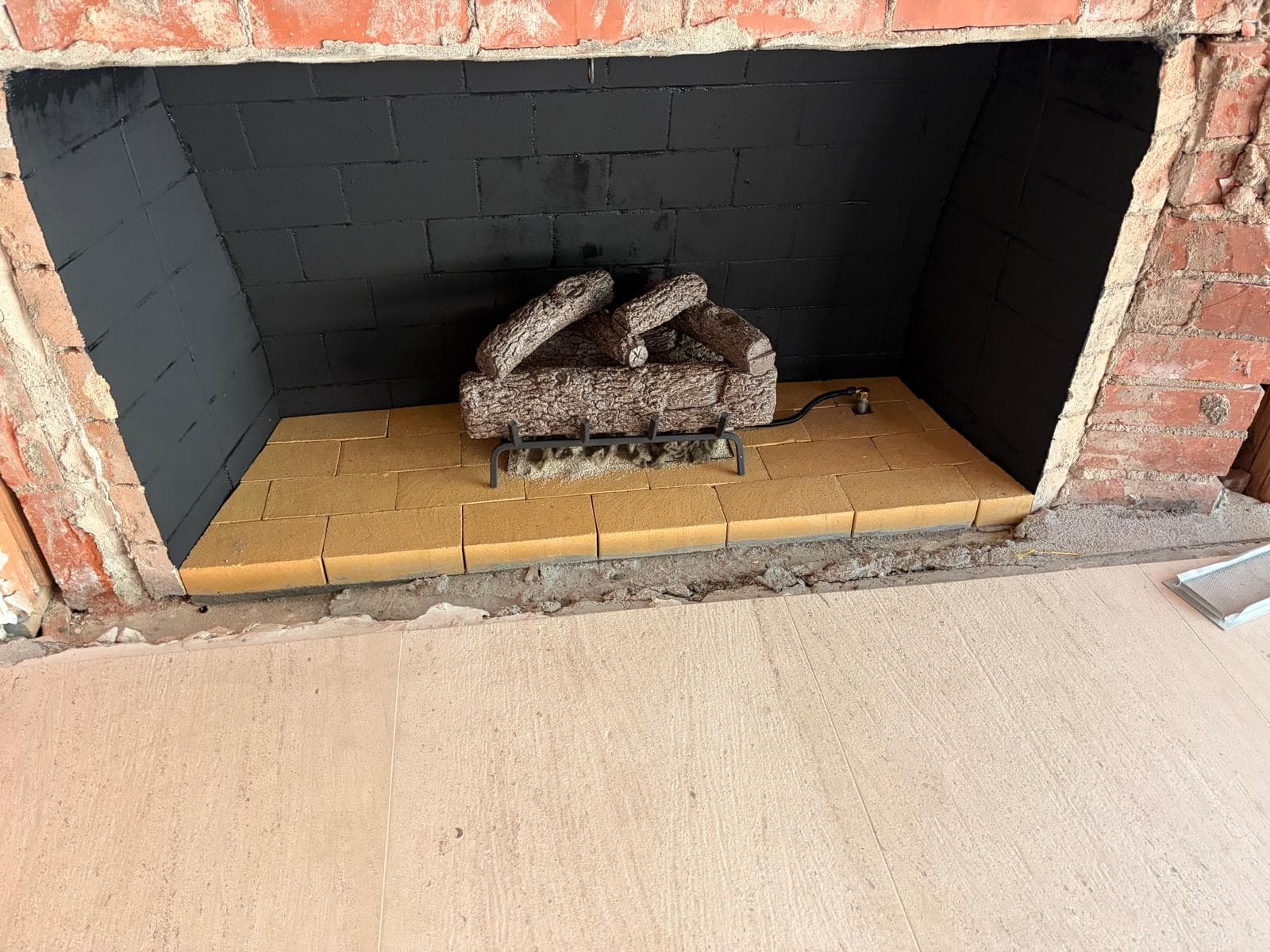 Completed gas log set installation with realistic flame in firebox