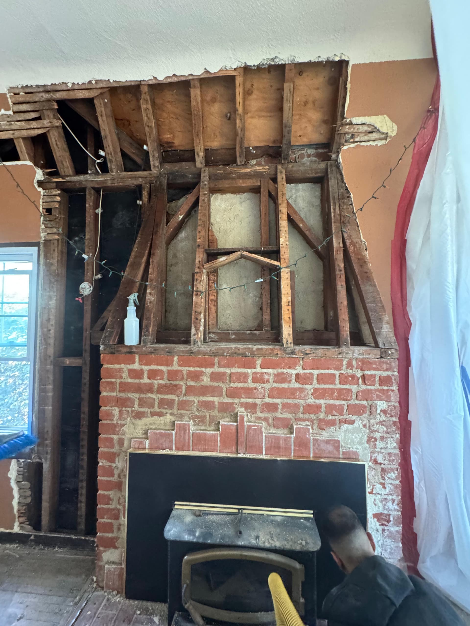 Demolition of water-damaged drywall revealing mold and moisture damage behind the wall