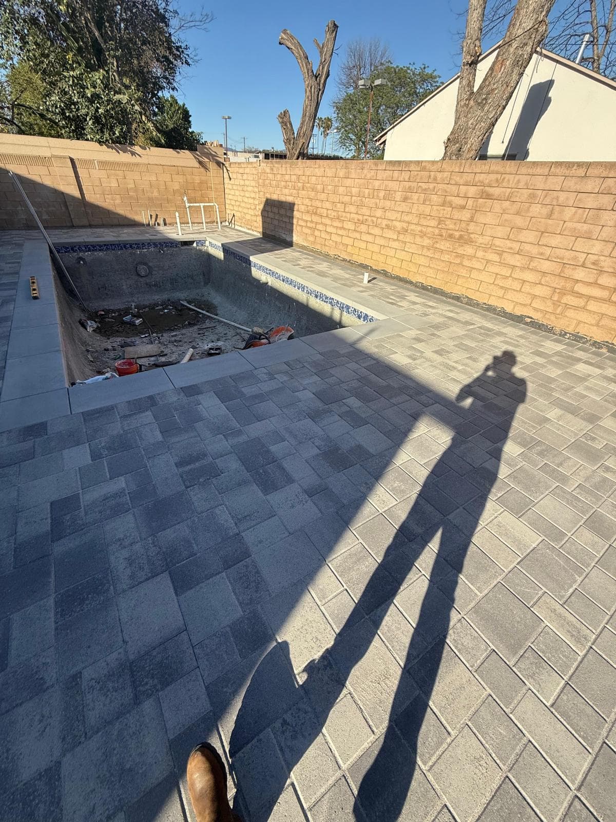 Completed paver deck and coping surrounding a finished pool