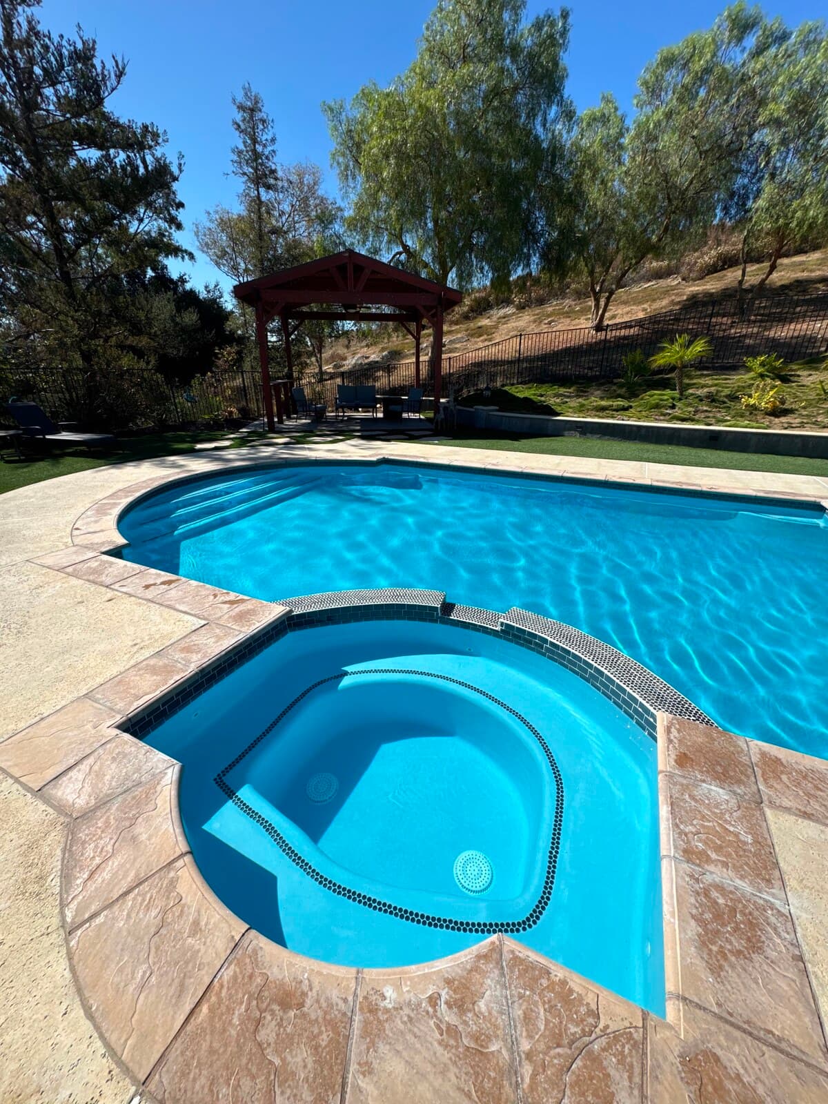 Finished pool and spa after replastering and new waterline tile seen across the deck