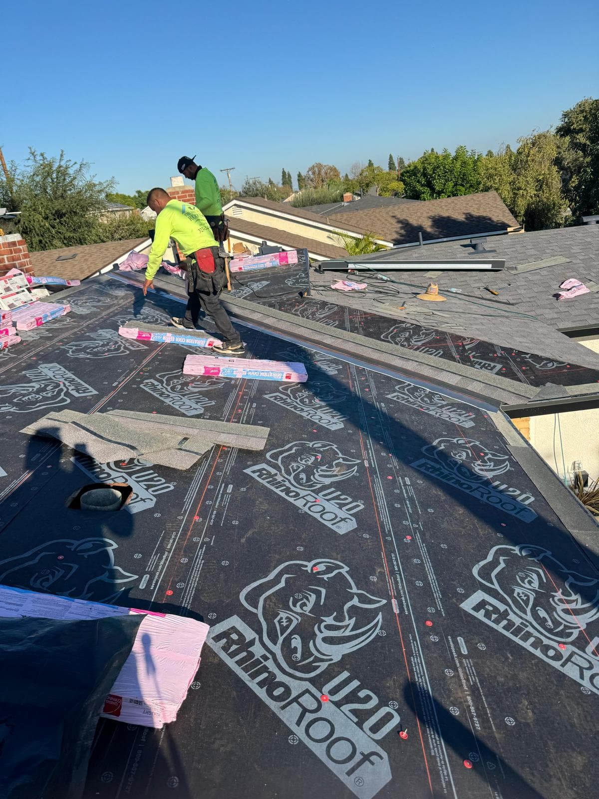 Roof replacement in progress showing underlayment installation after tear-off