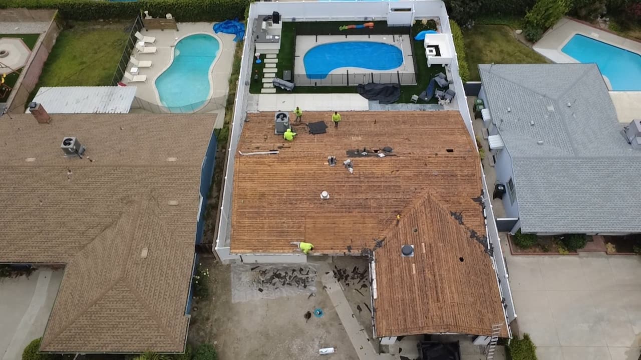 Roof before replacement showing worn and aging shingles across the slope