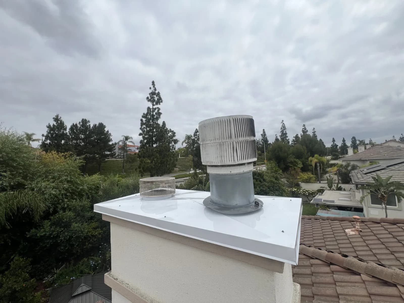 New bonderized steel chase cover installed on a residential chimney chase, replacing the rusted original