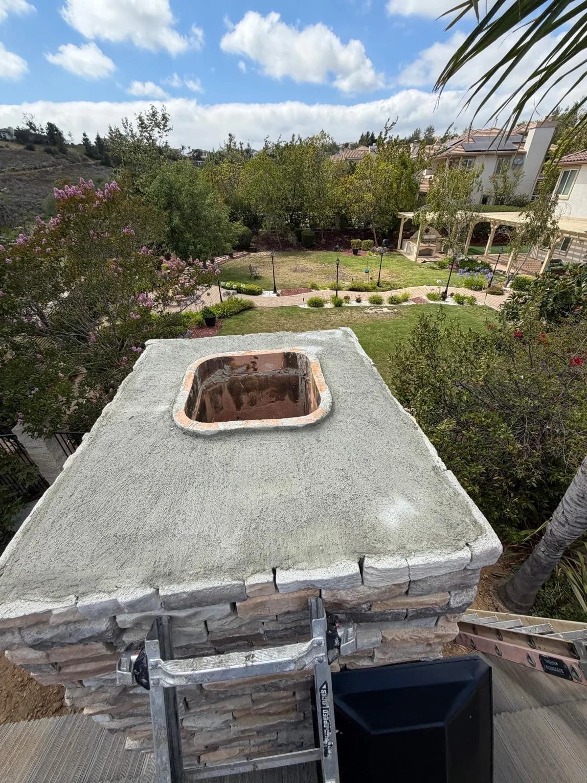 Second angle of chimney cap installation showing fit and alignment on the crown