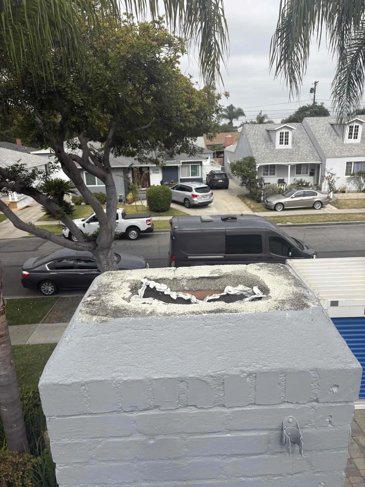 Custom chimney cap being positioned on the flue tile during installation