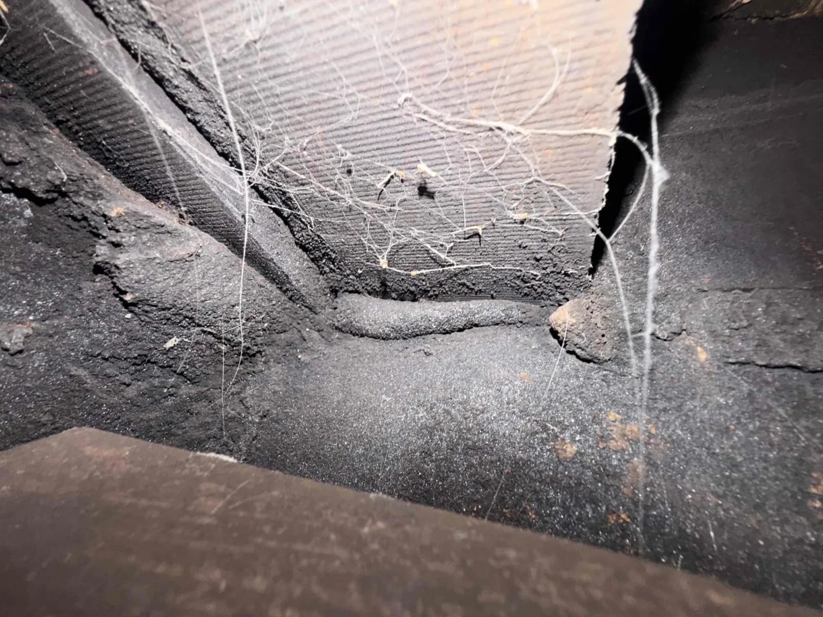 Heavy creosote buildup inside a fireplace firebox before PCR chemical treatment