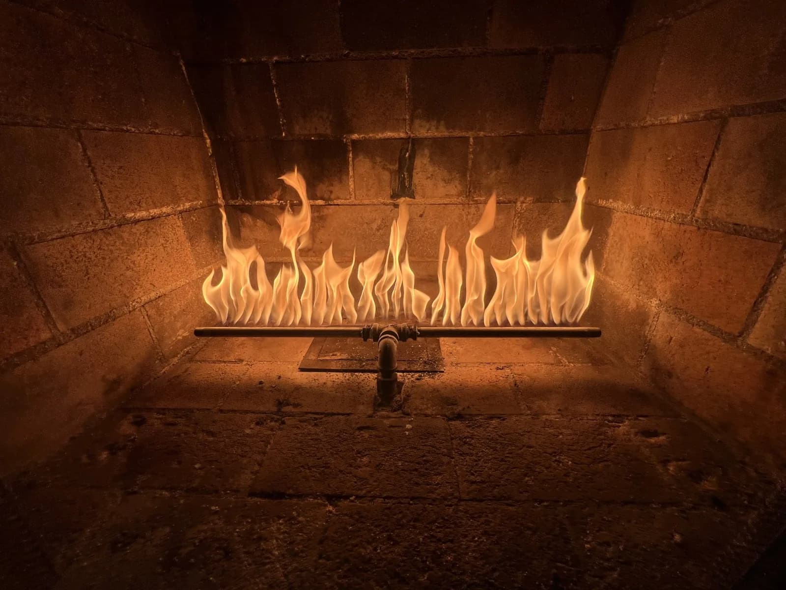 New gas log lighter installed in a fireplace firebox ready for wood burning
