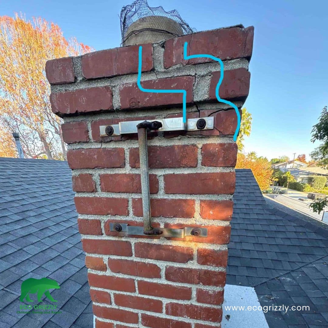 Technician identifying cracks and damage in a brick chimney during inspection