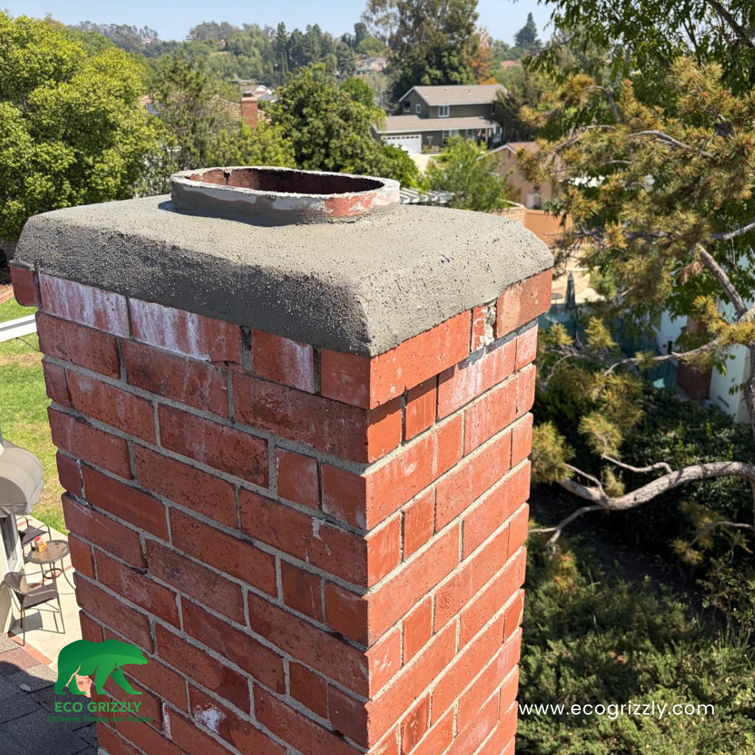 Brick chimney with newly repaired concrete crown and visible metal flue liner