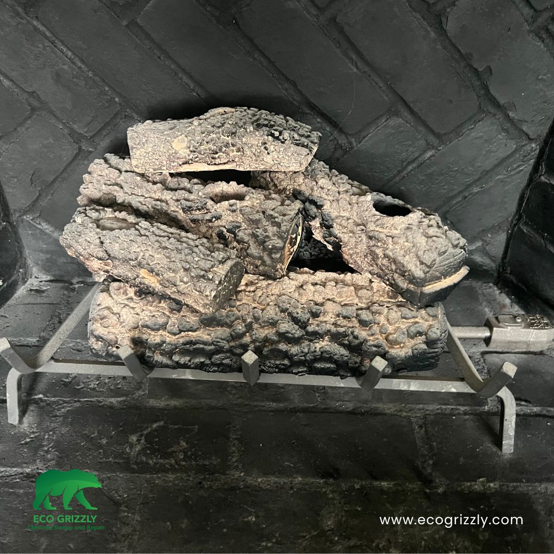 Deteriorated gas logs showing corrosion and wear found during chimney inspection