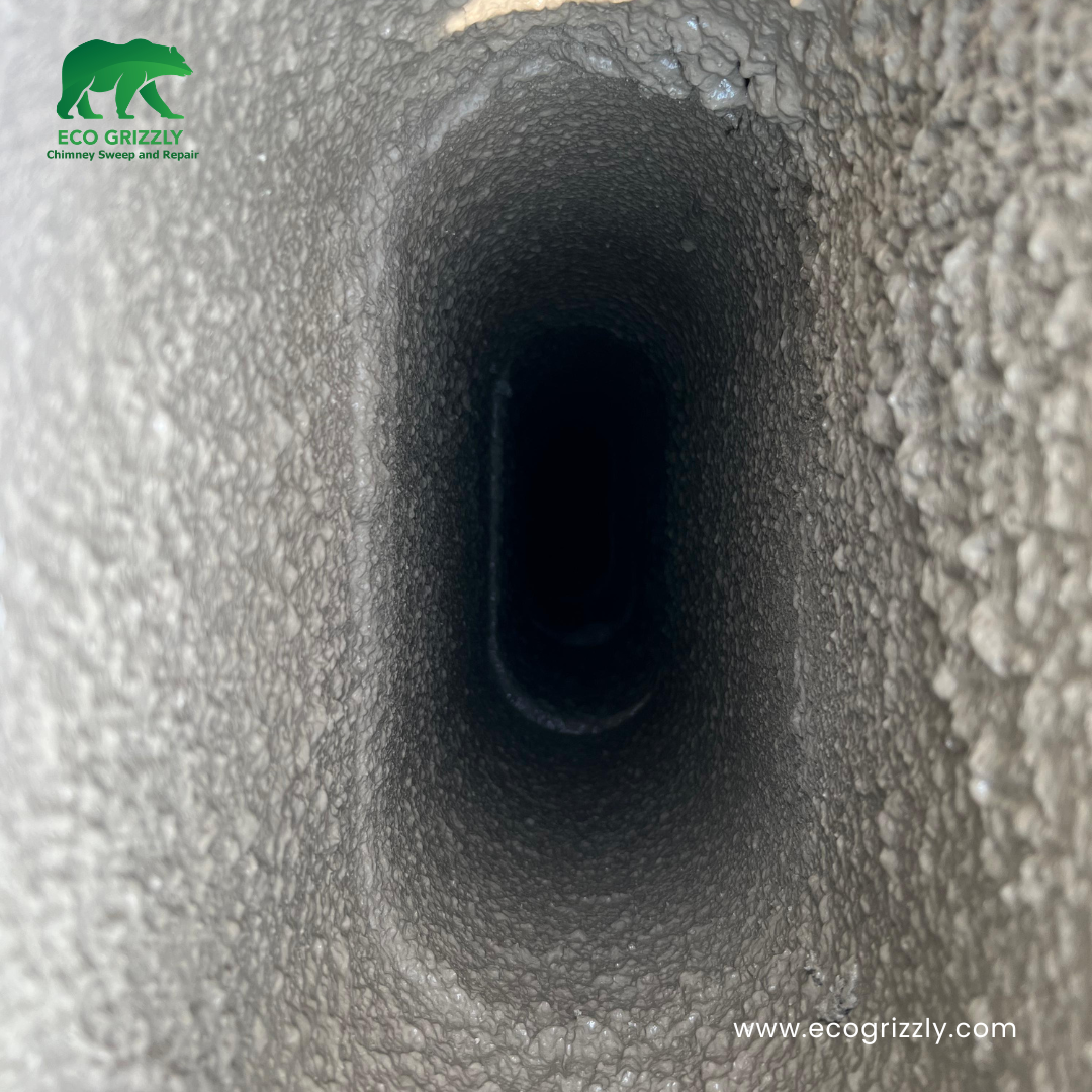 Chimney flue cleaning in progress showing brushwork and creosote removal