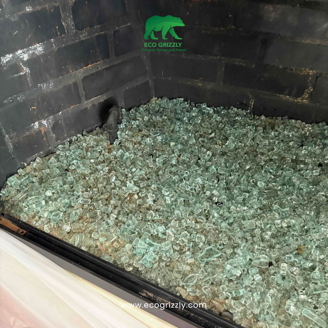 Fireplace filled with glass media and black brick walls during media replacement
