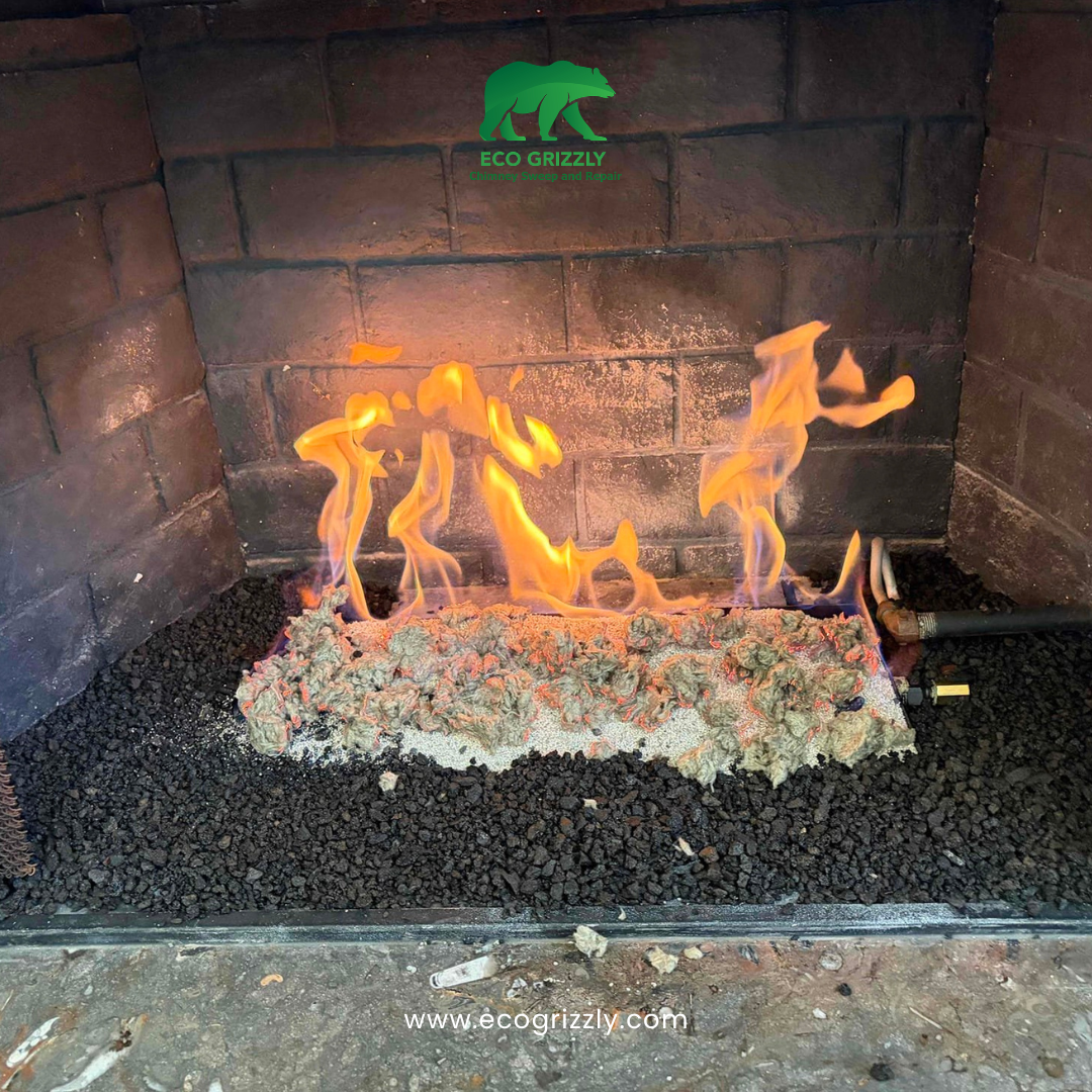 Gas fireplace with new logs burning in a brick firebox with side mesh screens