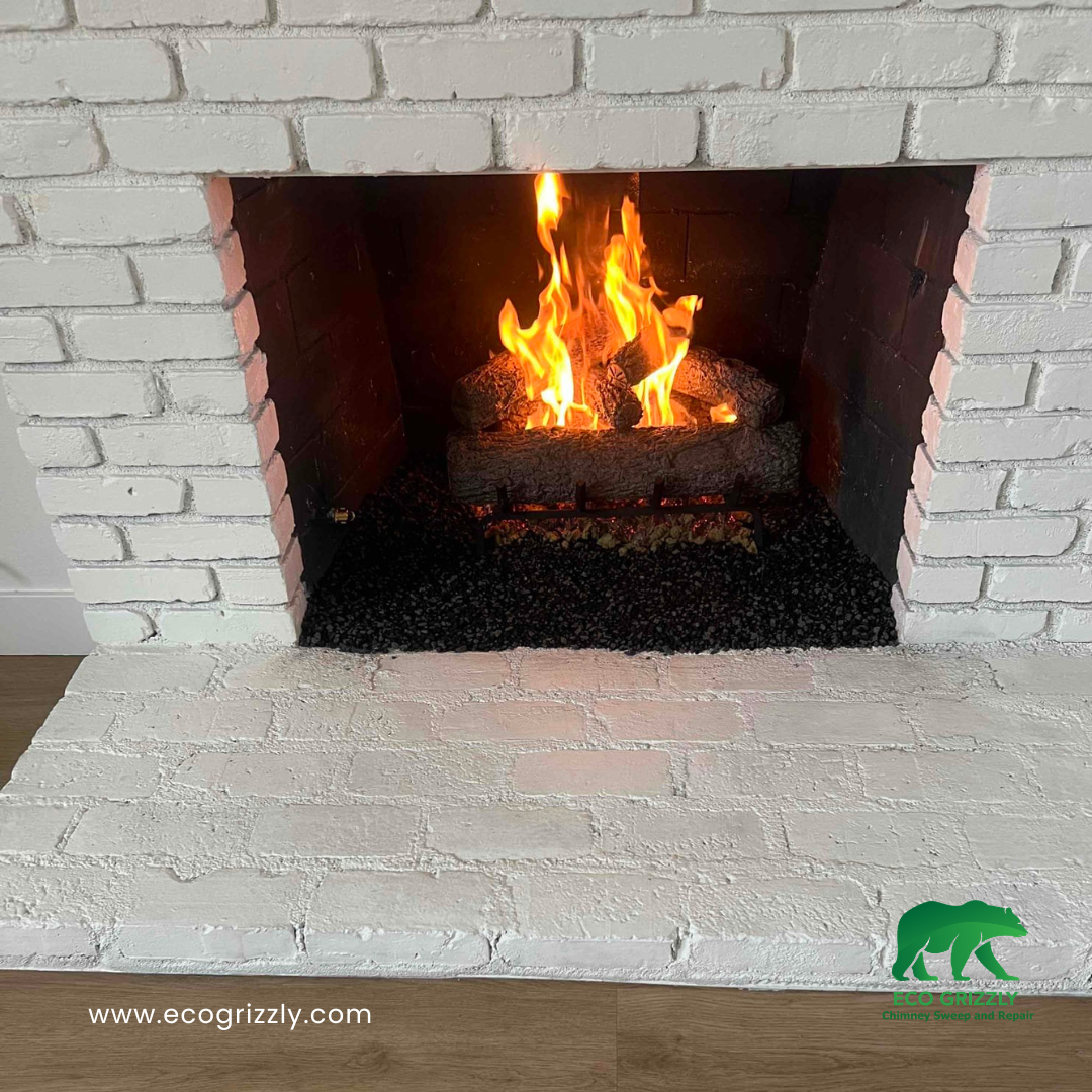 White brick fireplace with gas log set burning on a white brick hearth