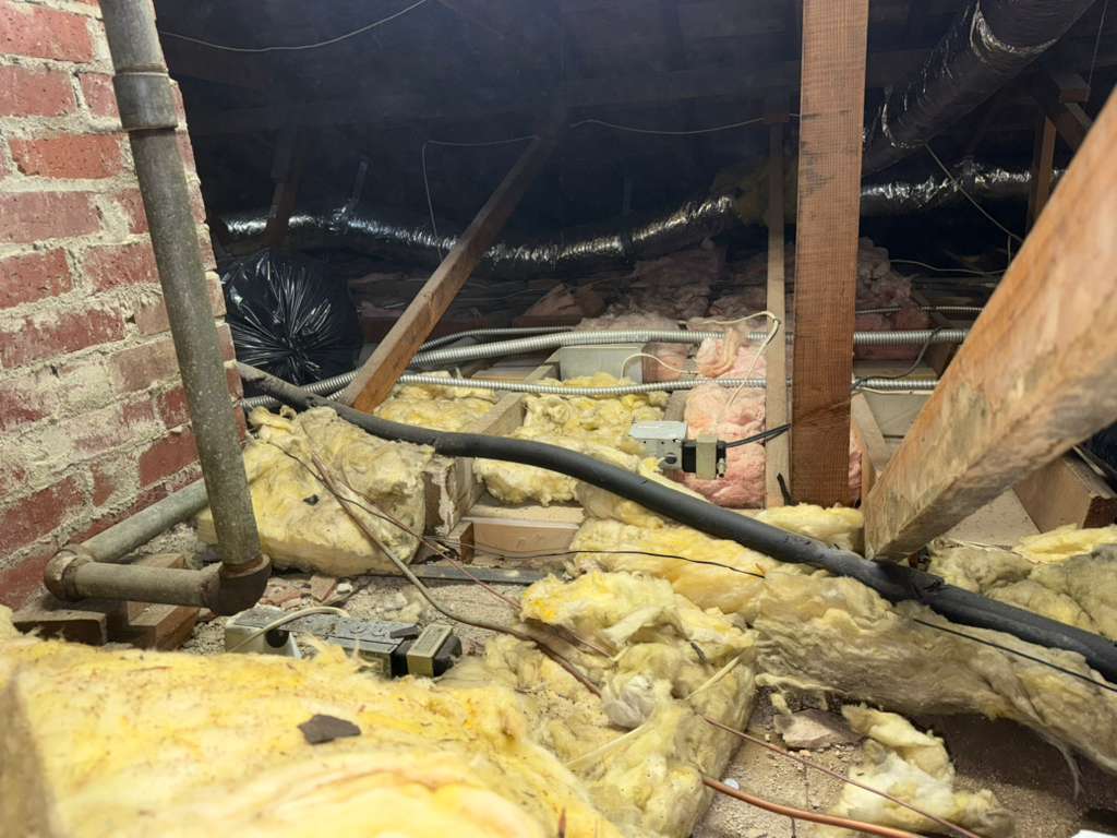 Another angle of attic with deteriorated insulation before removal